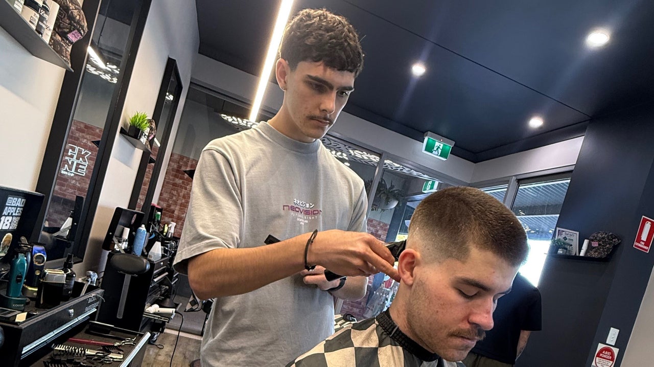 A Backbone barber working on a skin fade inside the Currumbin shop